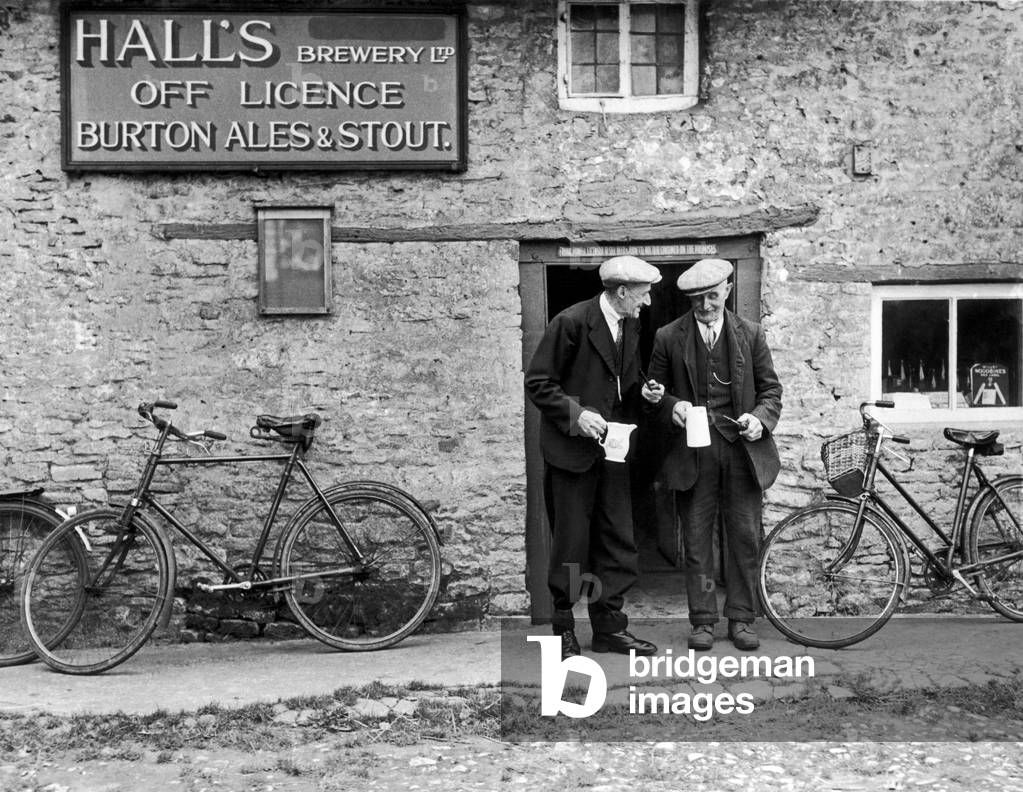 Halls Brewery Off Licence Burton Ales & Stout in Bucknell Oxford The village does not have a pub so locals have to purchase their beer at the off licence , but must not drink it on the premises. So the village green has become the local pub. 23/9/1946 (b/w photo)