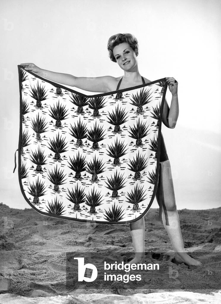 Model Roma Reeves wearing beach toga that doubles as a beach towel, May 1962 (b/w photo)