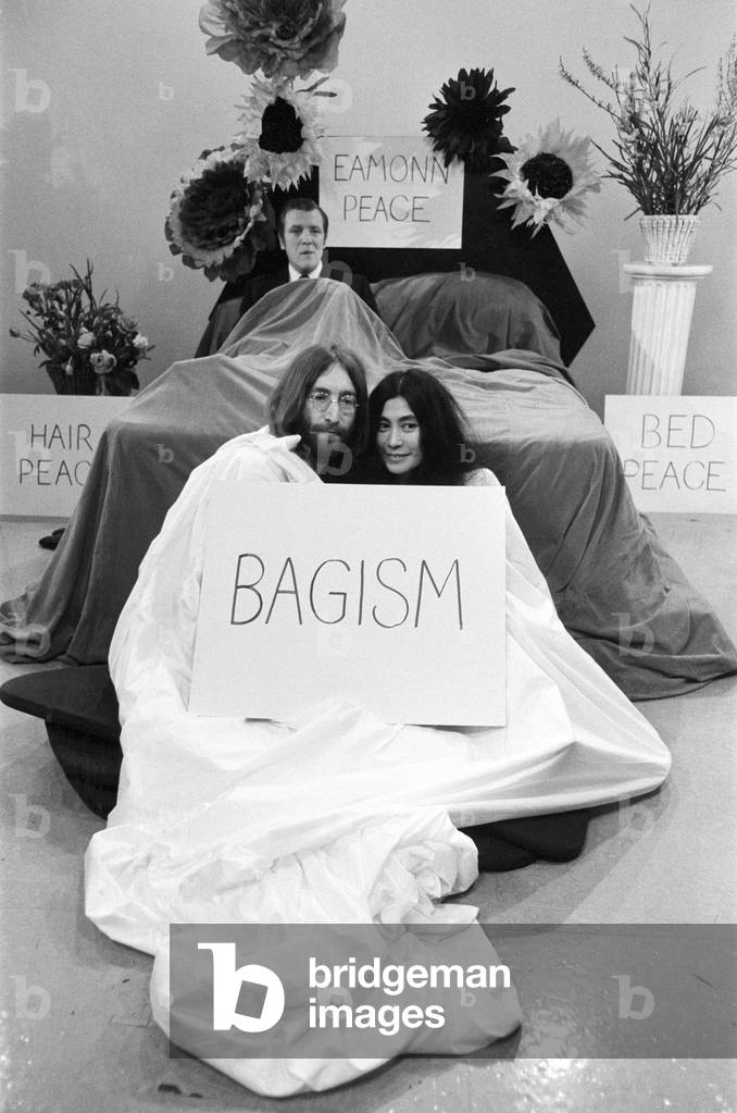 John Lennon and Yoko Ono appear on Thames Television's 'Today' programme with Eamonn Andrews. Eamonn started the programme in a bed and was joined by John and Yoko who emerged out of a bag at the bottom of the bed. 1st April 1969 (b/w photo)