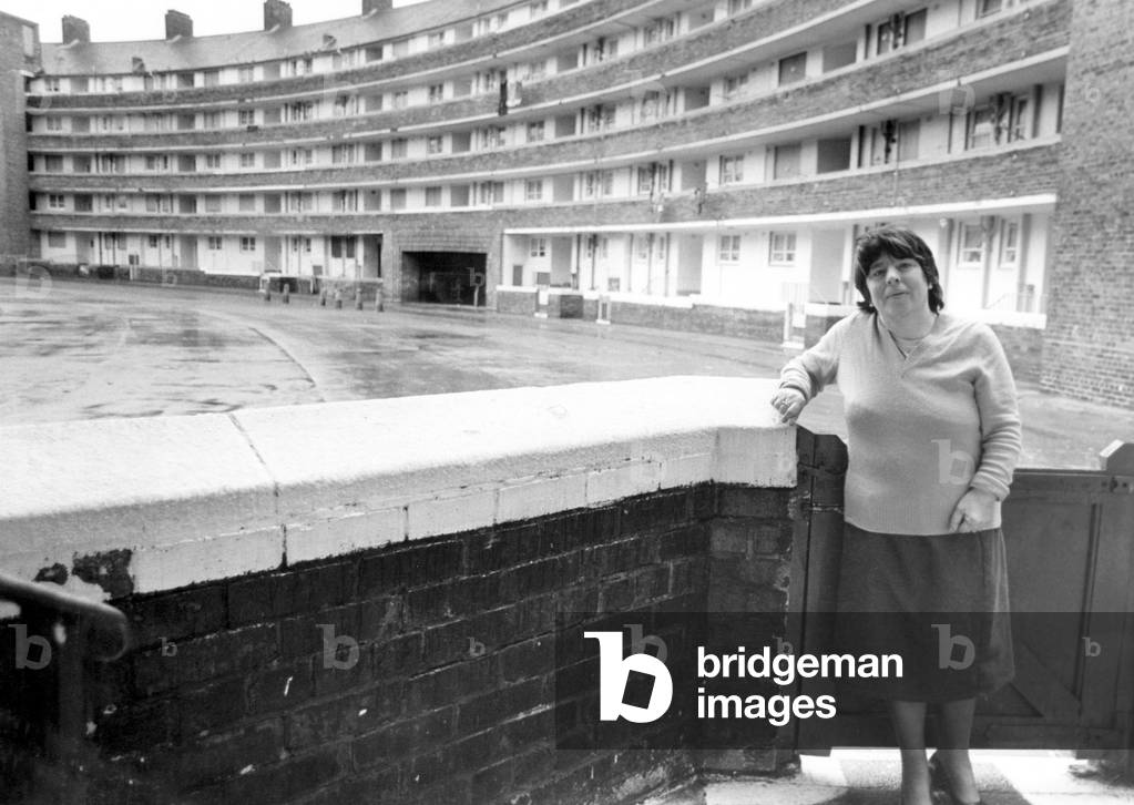 Dora Molloy, a resident of Gerard Gardens, a tenement block in Liverpool city centre. Designed and built in the 1930s by Architect, Sir Lancelot Keay. Dora believed she would be able to move into the new houses being built 100 yards away, but due to council policy which puts single people at the bottom of the housing list she has now been told she can't move into them. 22nd January 1986 (b/w photo)