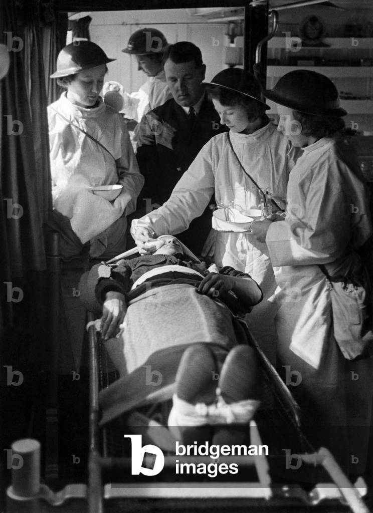 Nurses attending to patient on board hospital ship, March 1941 (b/w photo)