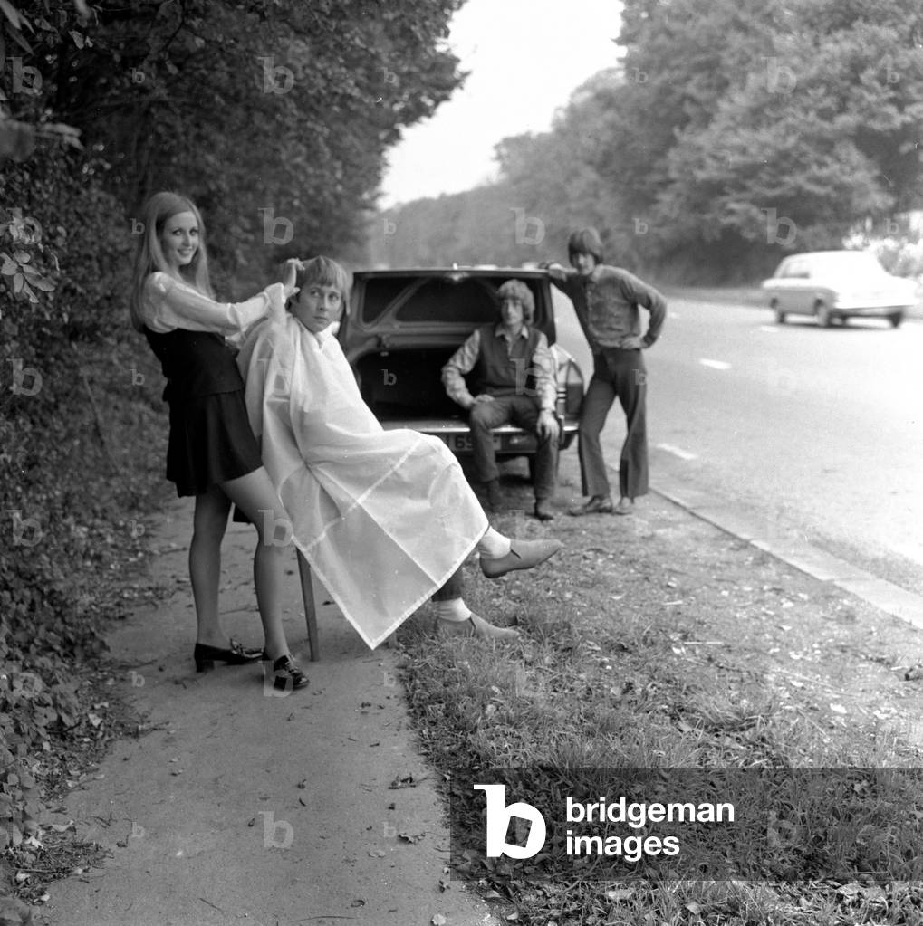 The untamed, Angie trims Lindsay Muir's hair, watched by (R to L)the drummer Des Mills and bass guitarist Ron Thomas November 1968 (b/w photo)