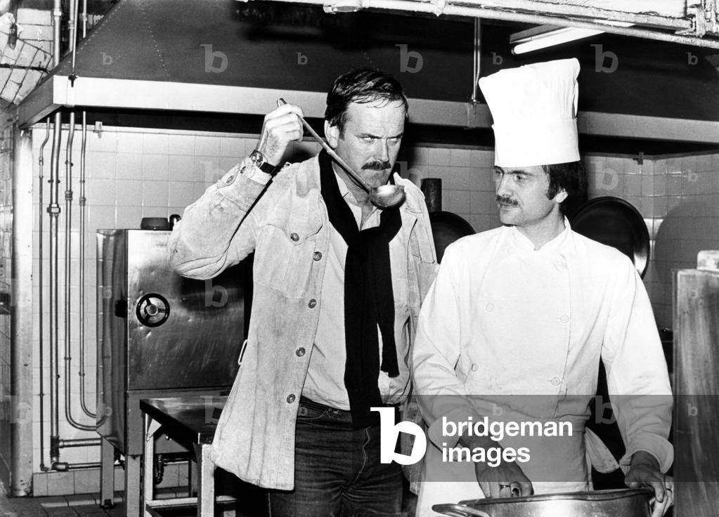 The soup-sampler is chef's nightmare Basil Fawlty. In the shape of John Cleese, Basil was in Newcastle to promote the latest book of scripts for the hit TV series Fawlty Towers. The world's most disaster prone hotelier couldn't resist springing a surprise visit to the kitchens of the Royal Station Hotel. Sous-chef Phil Stew was relieved when his soup was given the Fawlty seal of approval. 27th April, 1979 (b/w photo)