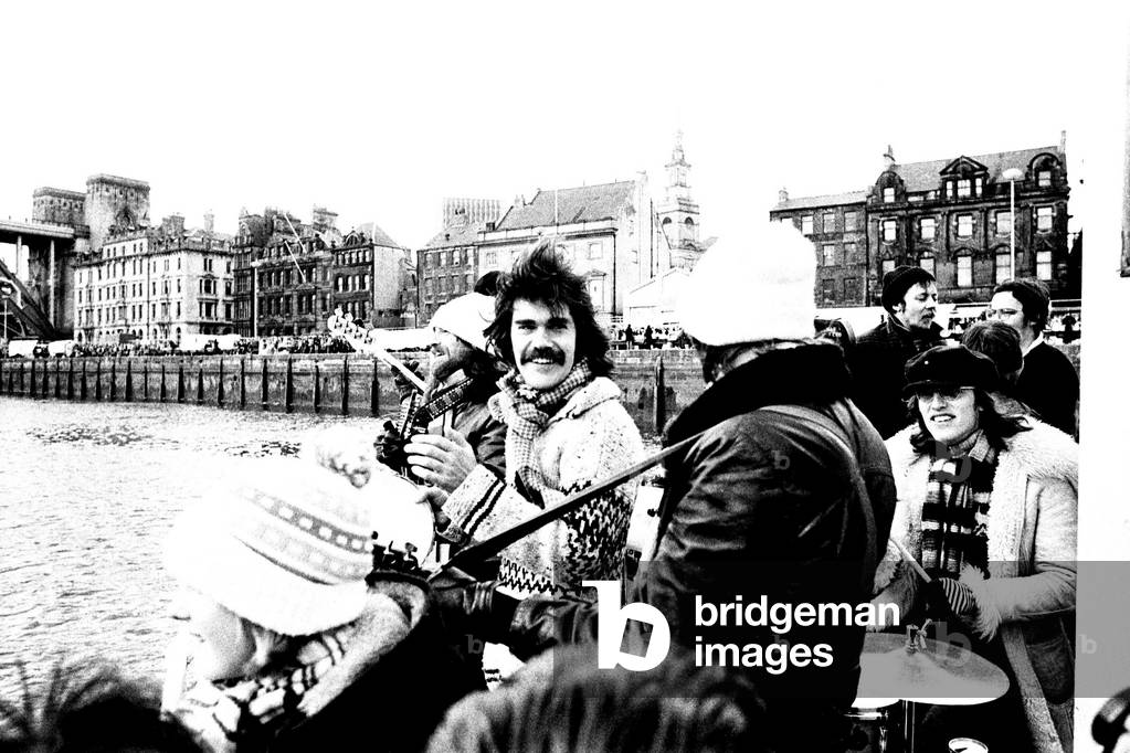 Lindisfarne sailed down the Tyne on a musical journey. The group were filming on board a Tyne ferry for a half-hour television show called 'All Right Now'. 4th March, 1979 (b/w photo)
