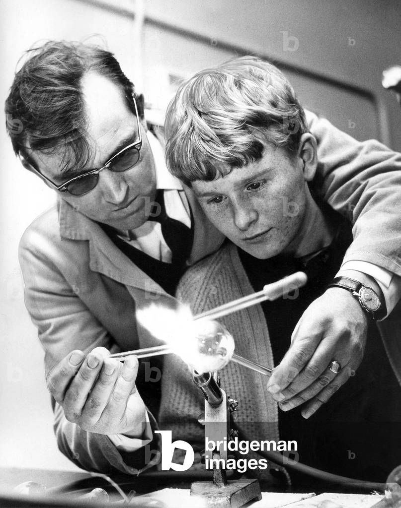 A scientific glass blower, Mr. Keith Hartley, instructs 17 year old Arthur Burdon in the glass-blowing class in November 1966 (b/w photo)