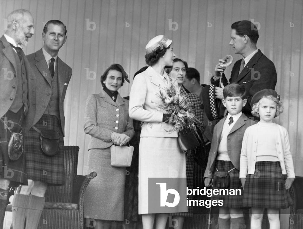 The Queen chats with Capt. A.C. Farquharson of Invercauld whilst the Marquess of Aberdeen speaks to the Duke of Edinburgh. The Marquess is Lord Lieutenant of Aberdeenshire and Chief of the Braemar Games. Left to right : The Marquis of Aberdeen, the Duke of Edinburgh, the Duchess of Cloucester, H.L. The Queen, H.R.H. Princess Margaret, the Royal children and Capt. A.C. Farquharson of Invercauld. September 1956 (b/w photo)