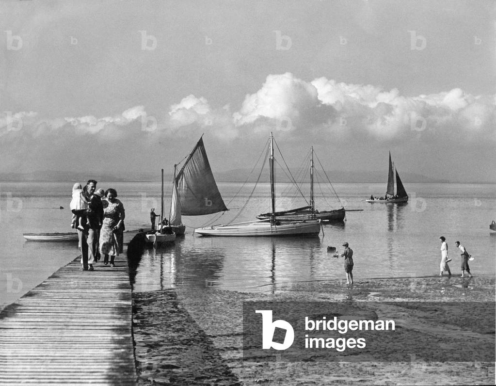 Holiday at Morecombe - Picture taken yesterday of holiday makers returning from a sail in the bay. The Lake District hills can be seen in the distance. 22nd August 1936