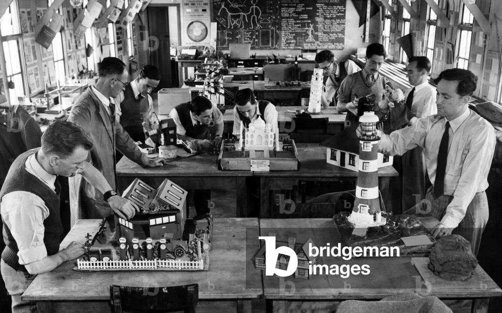 To-morrow's teachers are practical men. Some of the student teachers at Kirkby Emergency Training College with models they have made from waste materials. To construct the lighthouse, a jam jar, an ash tray and an ointment tin were used. 23rd June 1948 (b/w photo)