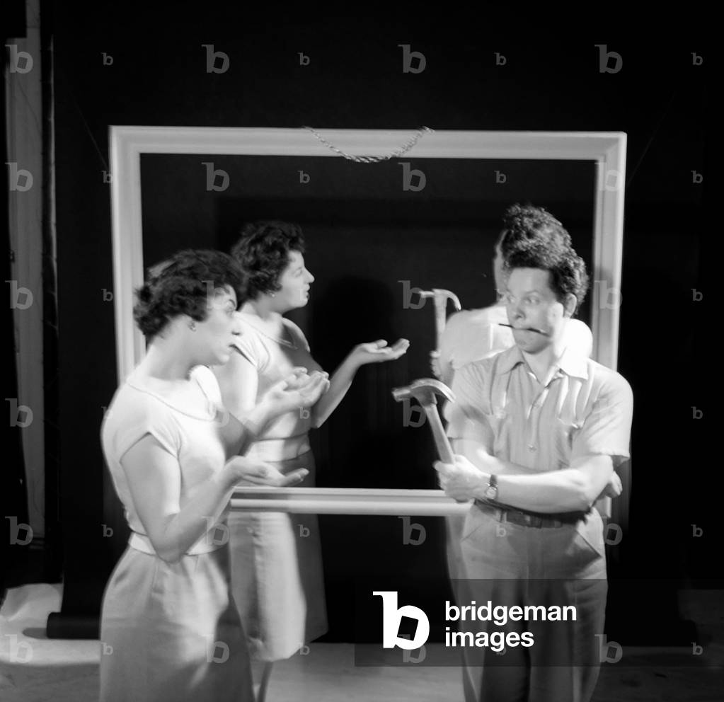 Mirror image: A couple argue in front of a mirror, 1958 (b/w photo)