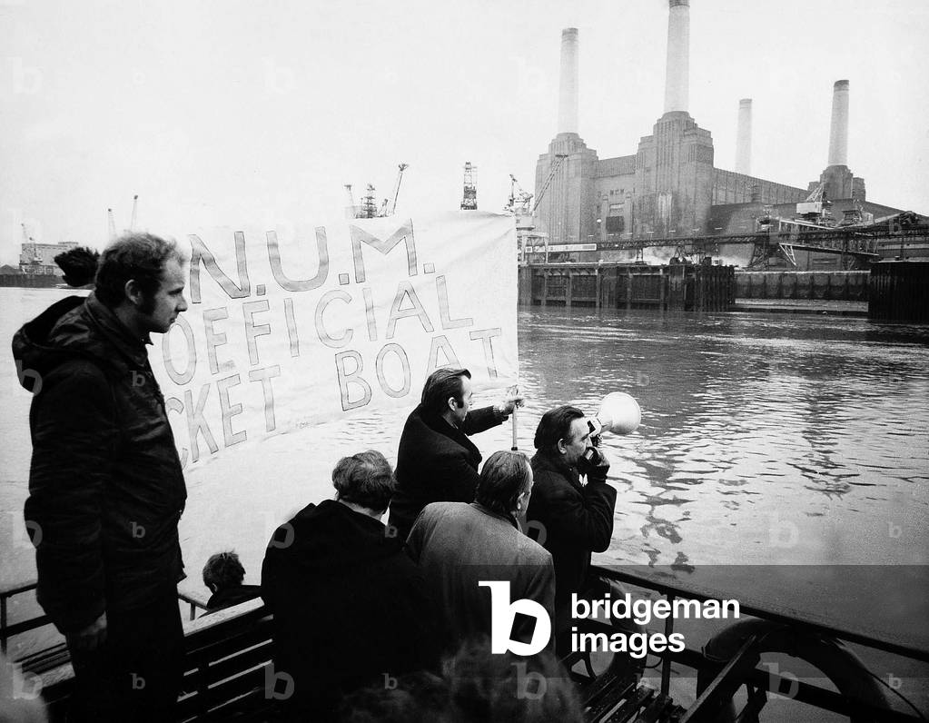 Mineworkers on strike picketing on the River Thames aboard Skylark passing Battersea Power Station, January 1972 (b/w photo)