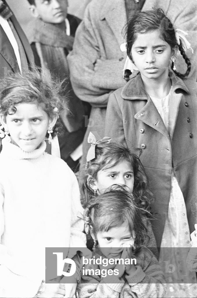 1968 East African Asian Crisis. Following Kenya achieving independence in 1963 Asians living in Kenya, were given two years to acquire Kenyan citizenship which in turn meant they had to renounce their British passports. Out of approximately 180,000 Asians fewer than 20,000 had submitted their applications by the deadline. Those Kenyan Asians without citizenship soon became subject to increasing discrimination. By 1967 the Kenyan Government enacted the Kenyan Immigration Act which required them to acquire work permits, whilst a Trade Licensing Act passed in the same year limited the areas of the country in which non-Kenyans could engage in trade. The Asian community became increasingly threatened as the Kenyan government cast them as a scapegoat group. Many choose to utilise their British passport and settle in the United Kingdom. This influx from East Africa lead the UK government to introduce The Commonwealth Immigration Act 1968 This Act took away the right of residence unless the passport holders were 'patrials' - descendents of people (parents or grandparents) born, adopted or naturalised in the UK. While the people coming from Kenya had British passports, many had not been to the UK before. The 1968 Act effectively revoked British citizenship and made thousands of people stateless. Our Picture Shows: Children of a young Asian family arriving at Heathrow fleeing political turmoil in Kenya, waiting at the airport to be collected by friends. 27th February 1968 (b/w photo)