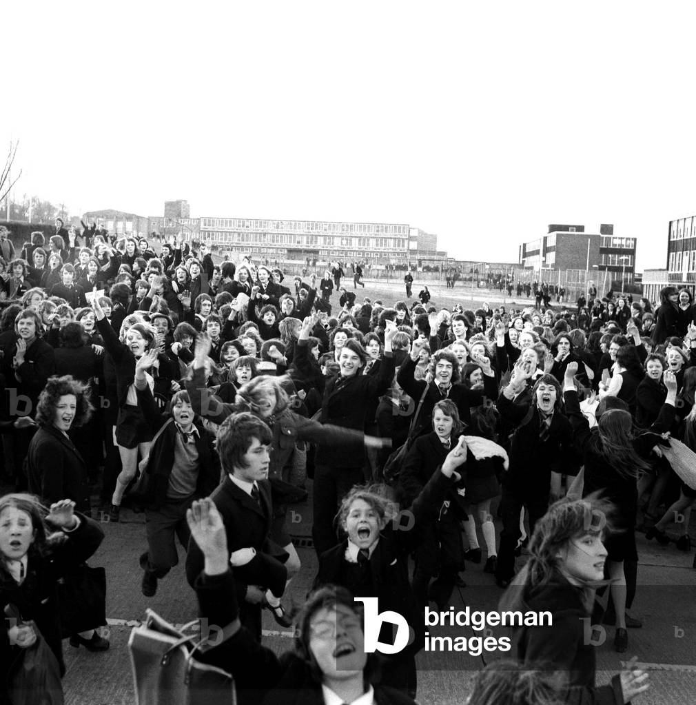 Pupils storm out of Kenton School, Newcastle, and run round the grounds chanting in protest at having to wear school uniforms, on November 11, 1974 (b/w photo)