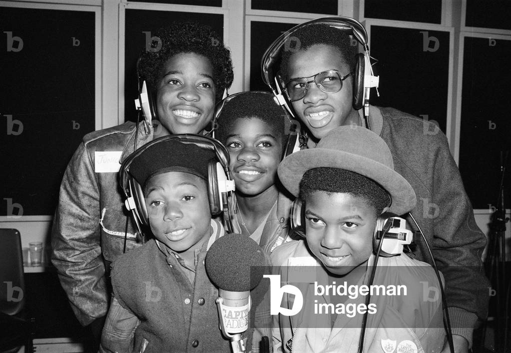 Musical Youth, British Jamaican pop / reggae group, at Capital Radio studios in London where they are helping to launch a road safety campaign involving glitter discs 8th October 1982 (b/w photo)