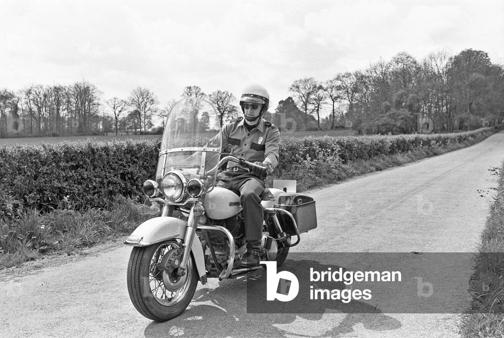 American police enthusiast John Hayes wearing the uniform of LA City Police officer and white helmet as he goes for a ride on his Harley Davidson motorcycle. May 1977.