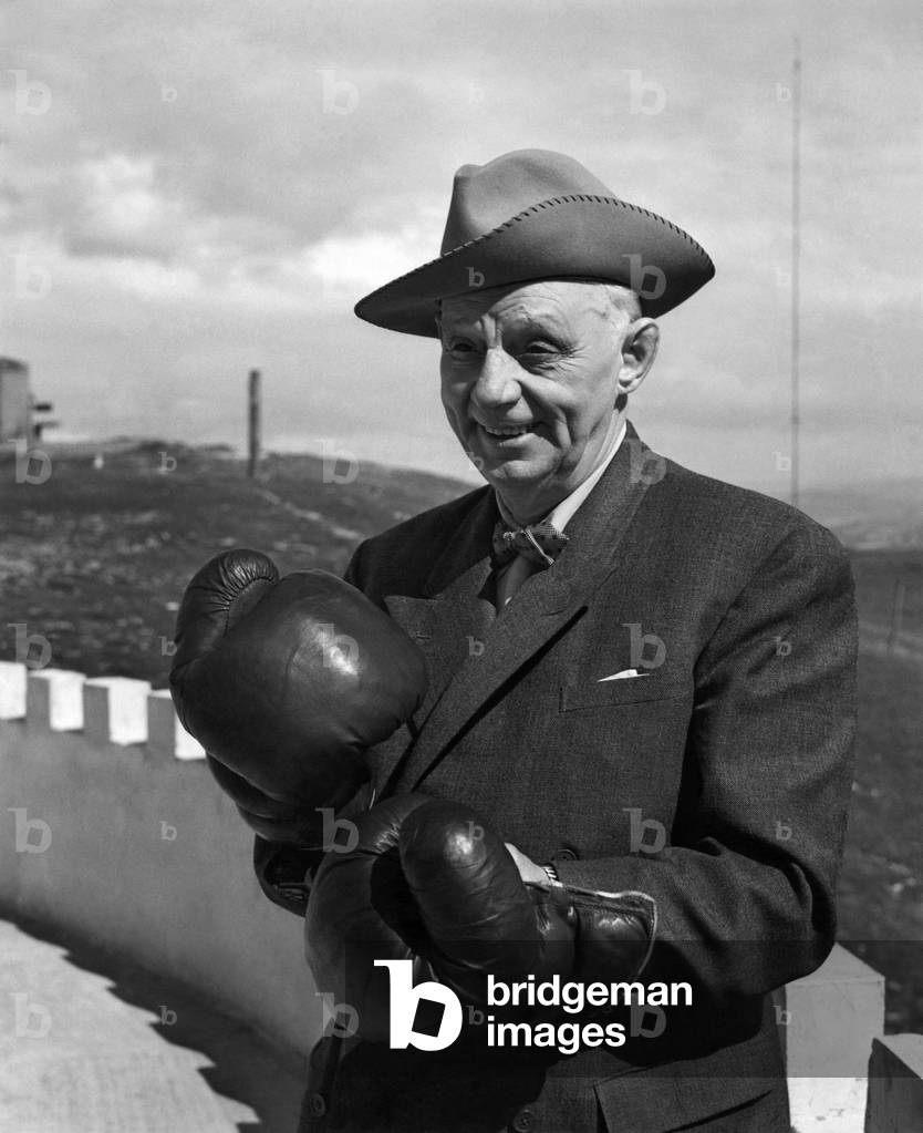 Jack Beynon of Fresco, California a retired boxing promotor visits Randy's Bar at Llandudno. He is holding a pair of famous Randy Gloves, 7th July 1964 (b/w photo)