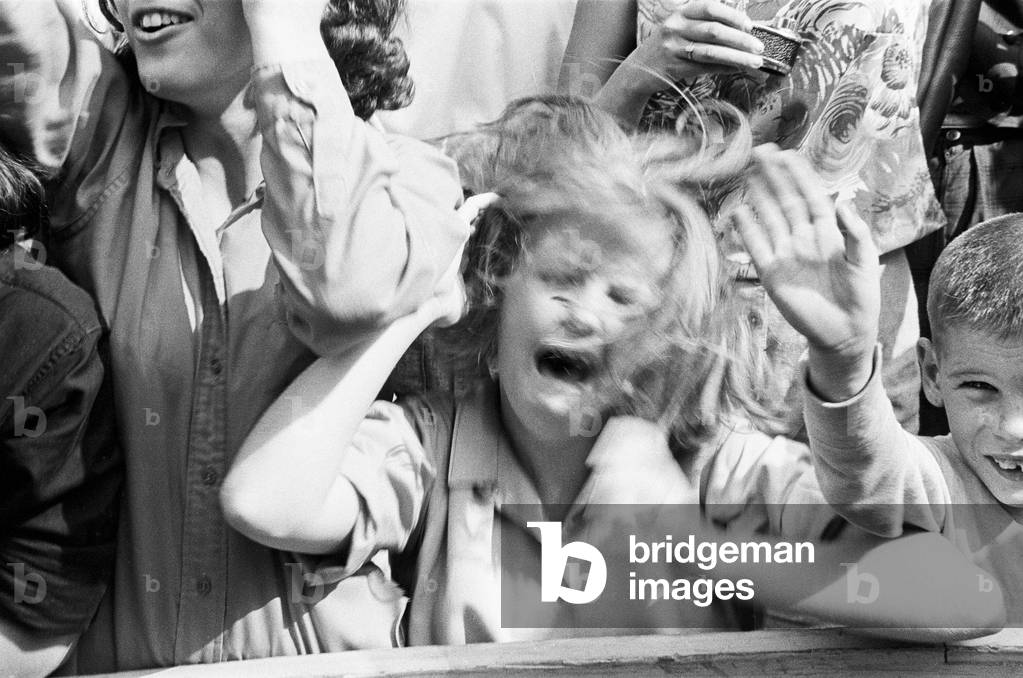 The Beatles in New York City, on their North American Tour ahead of their concert to be held at Forest Hills. Cheering fans gathered outside the Delmonico Hotel in New York where the band are staying. 28th August 1964 (b/w photo)