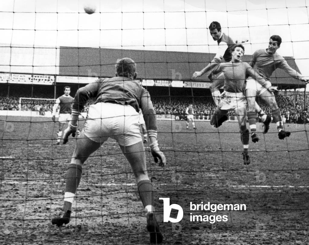 Peterborough v Swansea FA Cup 5th round match at London Road, Saturday 20th February 1965. Swansea goalie Briggs is ready to pounce as this shot by Peterborough's Derek Dougan goes over the bar, with Swansea defenders Hughes and PursellFinal score:Peterborough 0-0 Swansea Peterborough won replay 2-0 (photo)