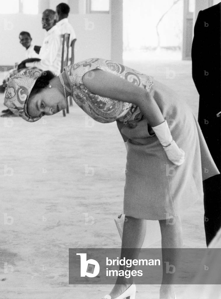 Her Majesty Queen Elizabeth II bends down to have a closer look under the frame of one of the boats made by local fishermen of the Maldives Islands during the royal visit there. 14th March 1972 (b/w photo)