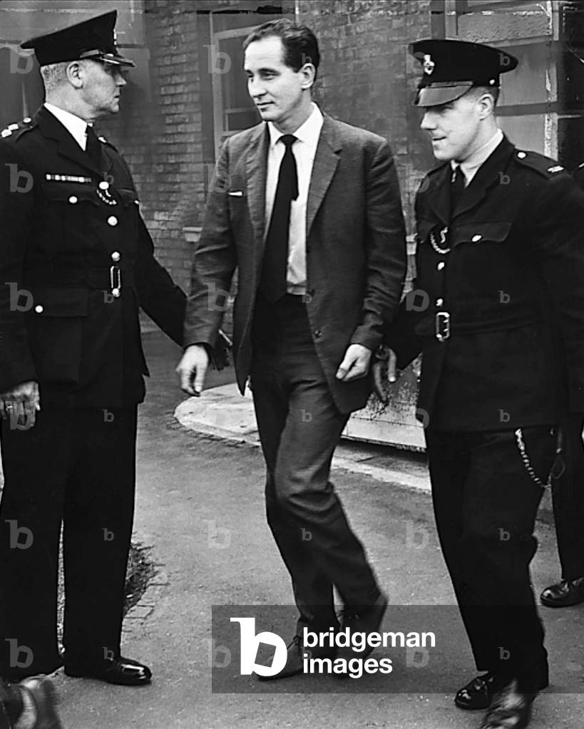 Ronnie Biggs, Accused train robber appears in court guided by two police officers, Aylesbury Crown Court, 10th September 1963.