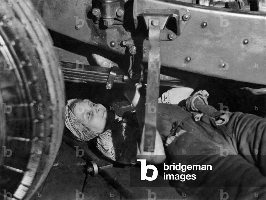 A women bus mechanic at work underneath the vehicle. June 1941
