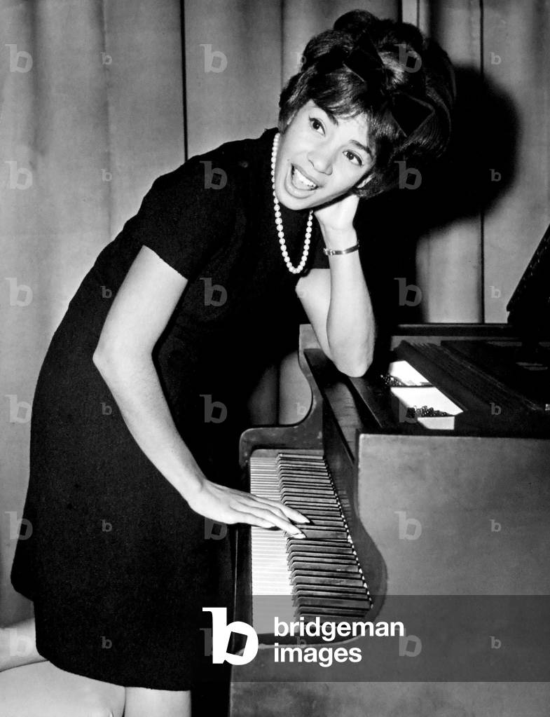 Shirley Bassey tries her hand at the piano during a press conference in the Cocktail Lounge of the 