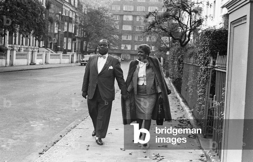 Louis Armstrong seen here arriving for a press conference at the Mayfair Hotel, shortly before leaving for a tour of Africa accompanied by his wife Lucille. 12th October 1960 (b/w photo)