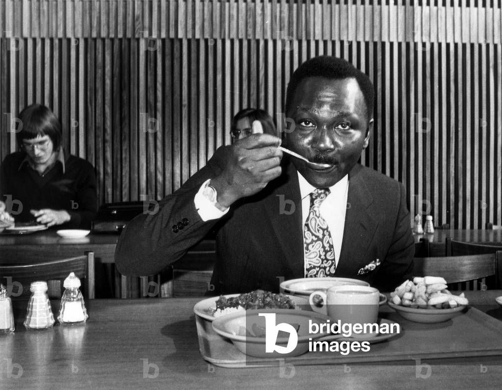 The former President of Nigeria General Yakubu 'Jack' Gowon who has enrolled at Warwick University for a three year degree course in Politics and International Social Studies. The General is seen here eating lunch, 7th October 1975 (b/w photo)