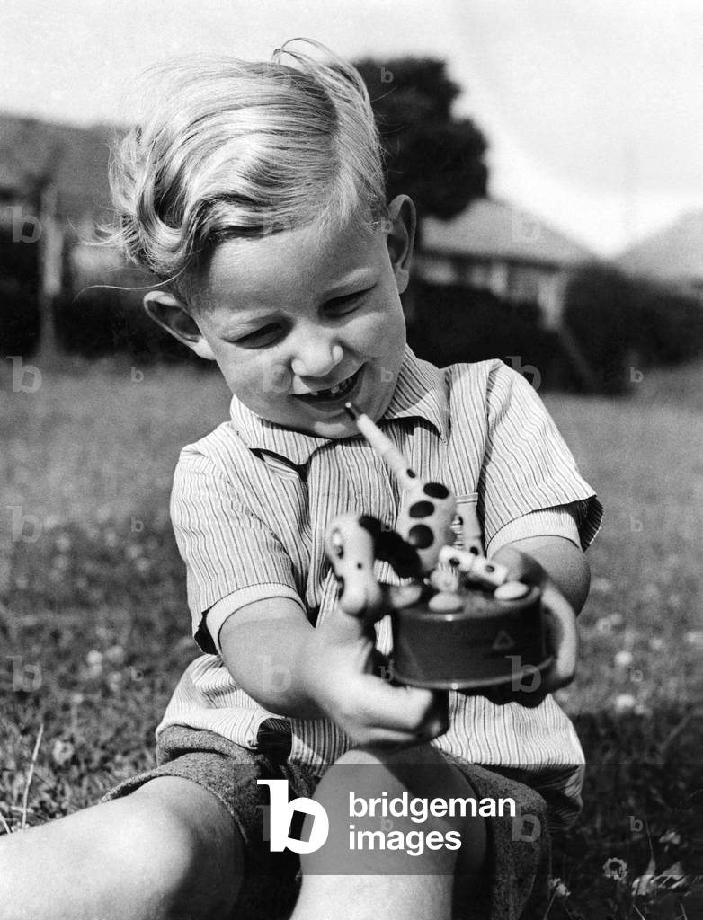 A boy's best friend is his dog, they say, but how about when that dog is mechanical? That's a problem being faced by many British parents now that mechanical toys are appearing on the market again - for the first time in six years. British kids of six, or under, have never known what it is to have a regular, brand- new toy, and you can never be quite sure how they'll take to innovations! Here you see one youngster's typical reaction. The mechanical dog is 