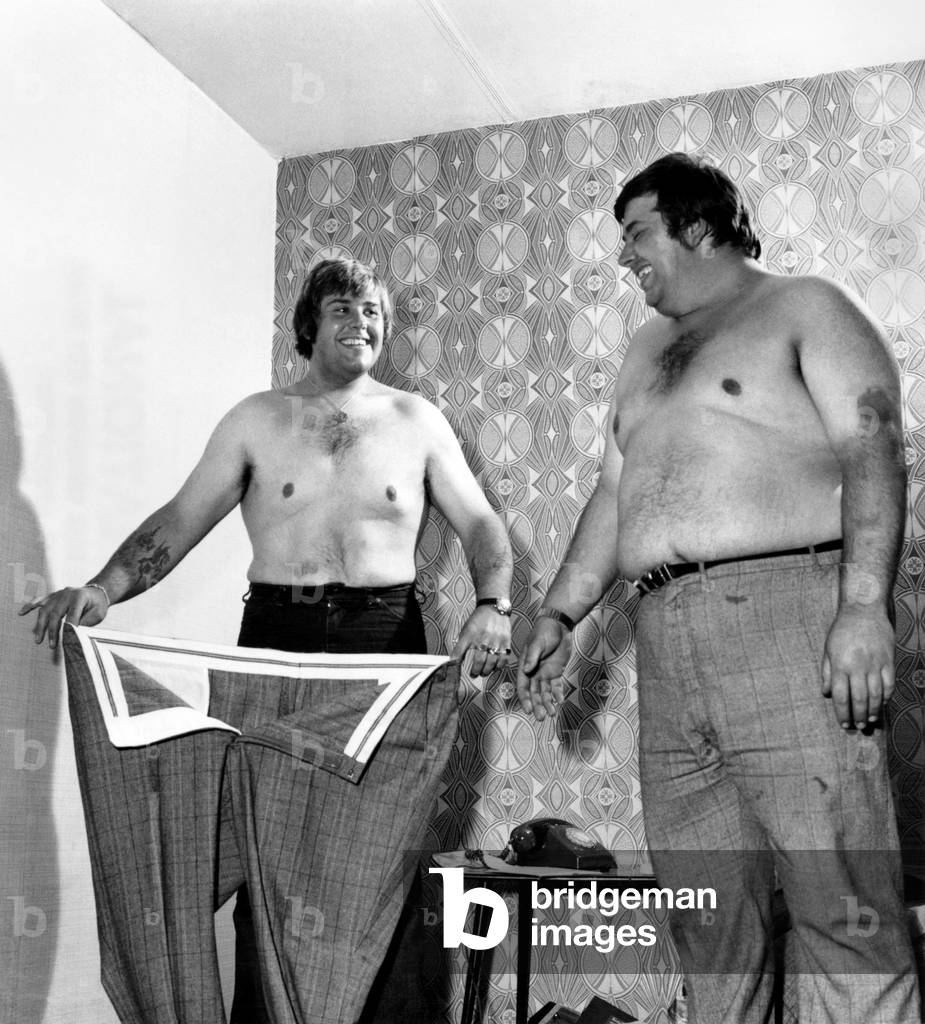 Terry's old suit, much too big now, still fits tubby brother Philip, June 1976 (b/w photo)