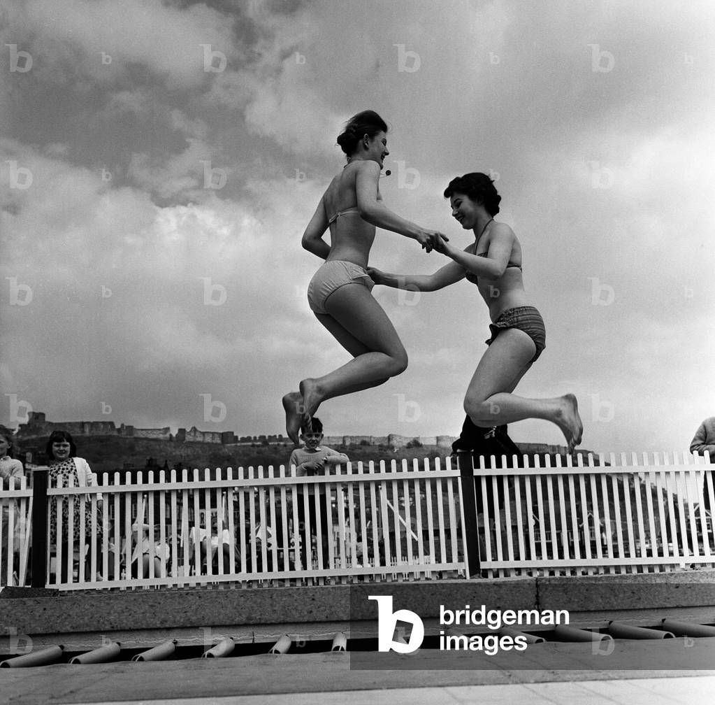 Trampoline on the sands at Scarborough, North Yorkshire. Pictured are Anne Churchill, 16, and Wendy Archer, 17. 14th May 1963 (b/w photo)