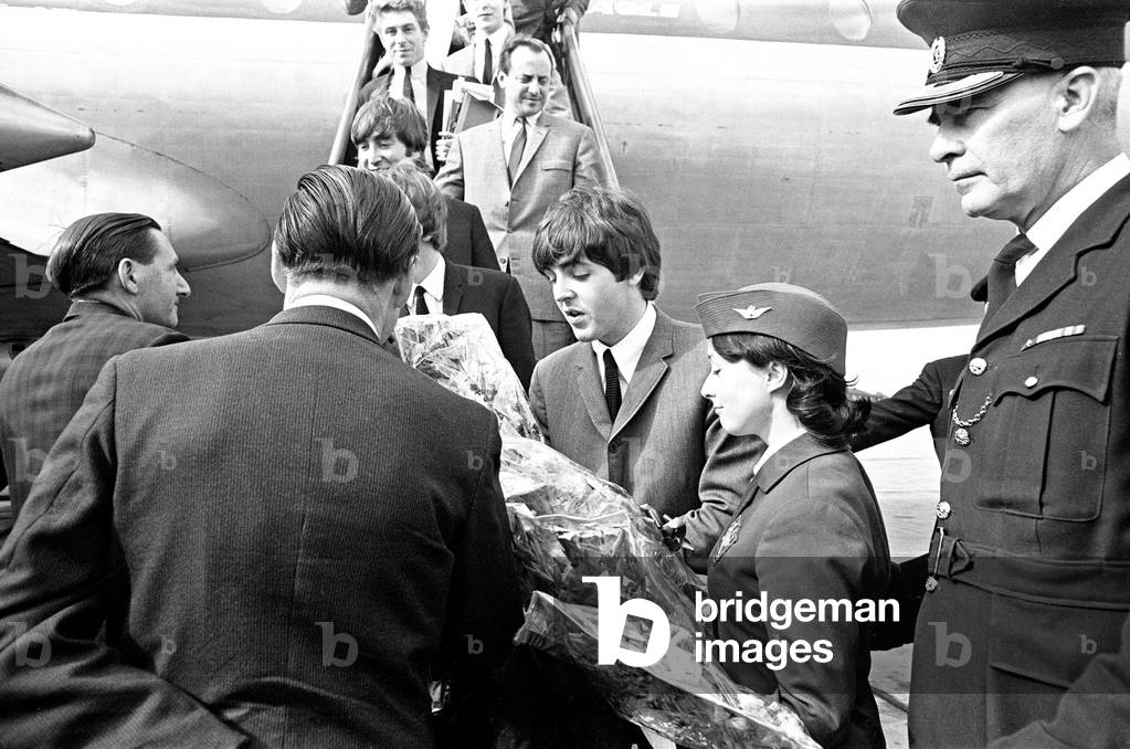 The Beatles in Liverpool for the Premier of a Hard Day's Night. Paul McCartney is presented with flowers as he walks down the stairs of the plane into a Liverpool airport. 10th July 1964.