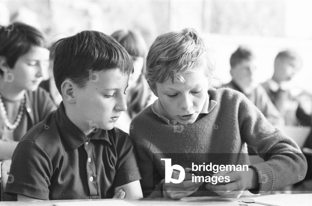 Forty French boys and girls aged between 9 - 11 from Boulogne are starting a fortnight's schooling at Cannonbury Primary School, Islington, London, N1. They came with forty Islington children who stayed with them in Boulogne, and in whose homes they will stay now. The exchange was the idea of Mrs Hilda Wurr headmistress of Cannonbury School where all the children are taught French from the age of 8. In Boulogne the English children had tuition all in French at the Ecole Cary for boys and girls at the Ecole Frederic Sauvage. But now it is the turn of the French children to have their lessons in English in a double mixed class with English boys and girls. Our Picture Shows: French pupils learning maths. 19th June 1967 (b/w photo)