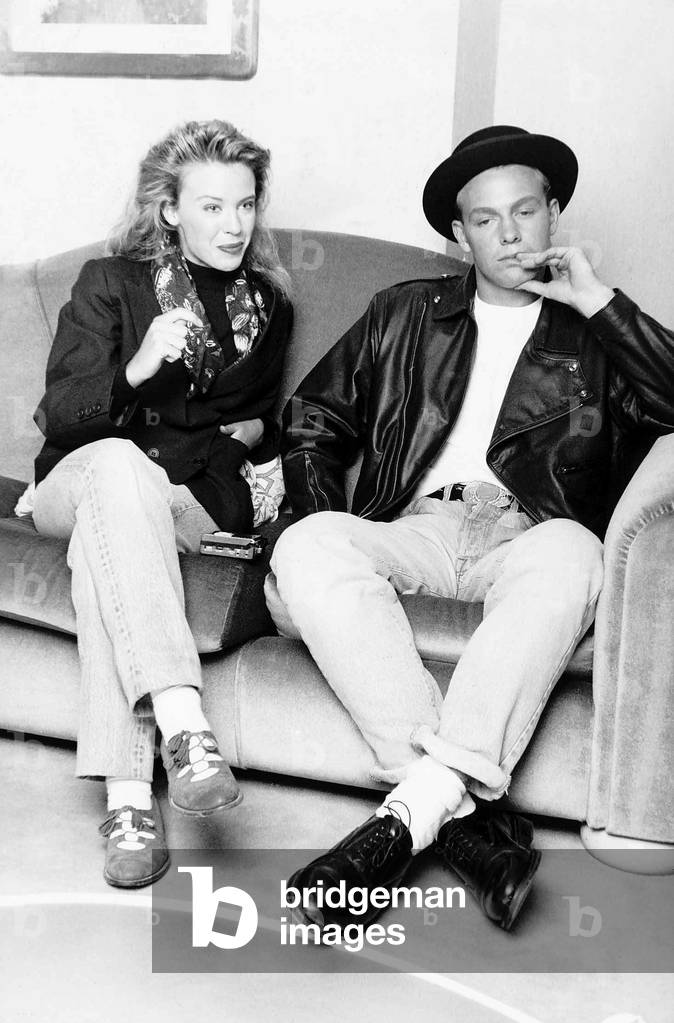 Kylie Minogue singer actress with Jason Donovan singer actor sitting on sofa, 1989