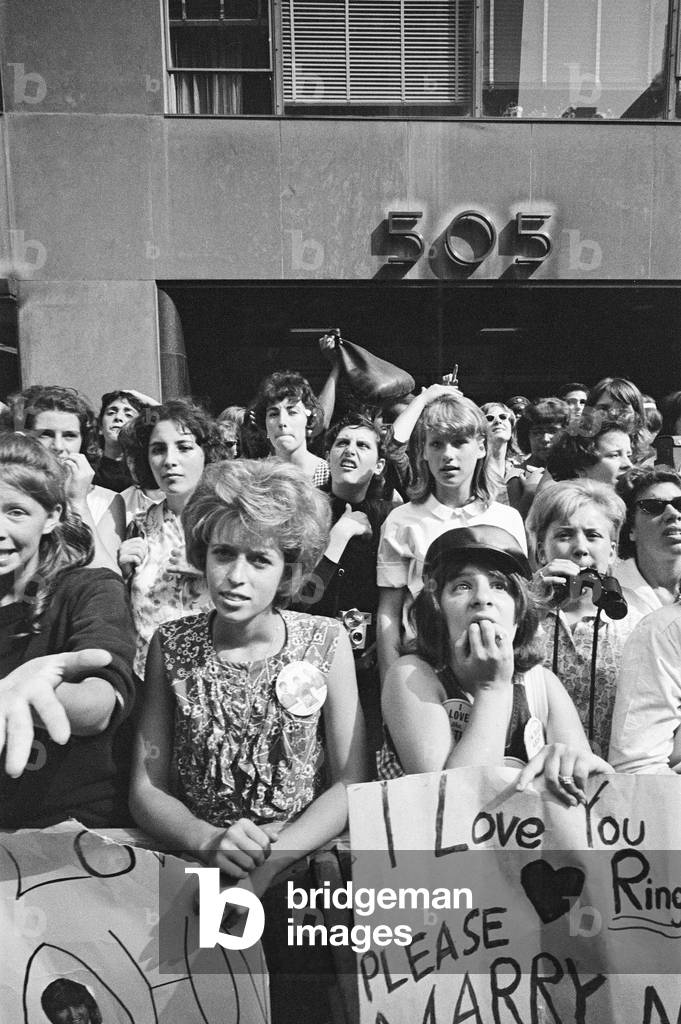 The Beatles in New York City, on their North American Tour ahead of their concert to be held at Forest Hills. Cheering fans gathered outside the Delmonico Hotel in New York where the band are staying. 28th August 1964 (b/w photo)