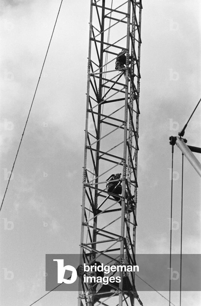 The collapsed Emley Moor transmitting station mast lies on the ground as engineers put the finishing touches to the BBC Two mast which towers 307ft off the ground. 16th April 1969 (b/w photo)