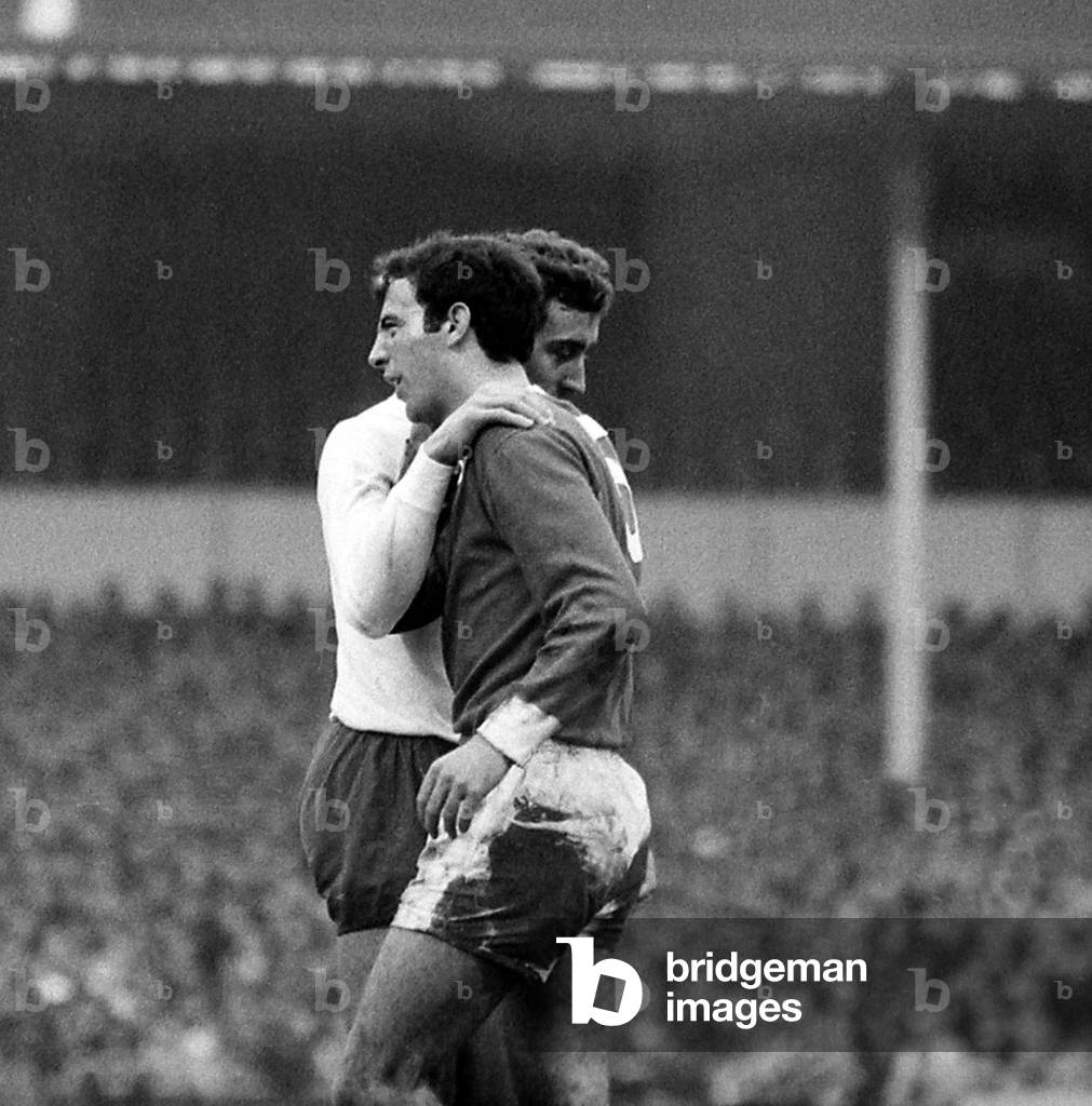 Martin Chivers of Tottenham Hotspur puts his arm round David Sadler of Manchester United as Bobby Charlton's shot goes in for the winning goal during their league match at White Hart LaneDecember 1968 (photo)