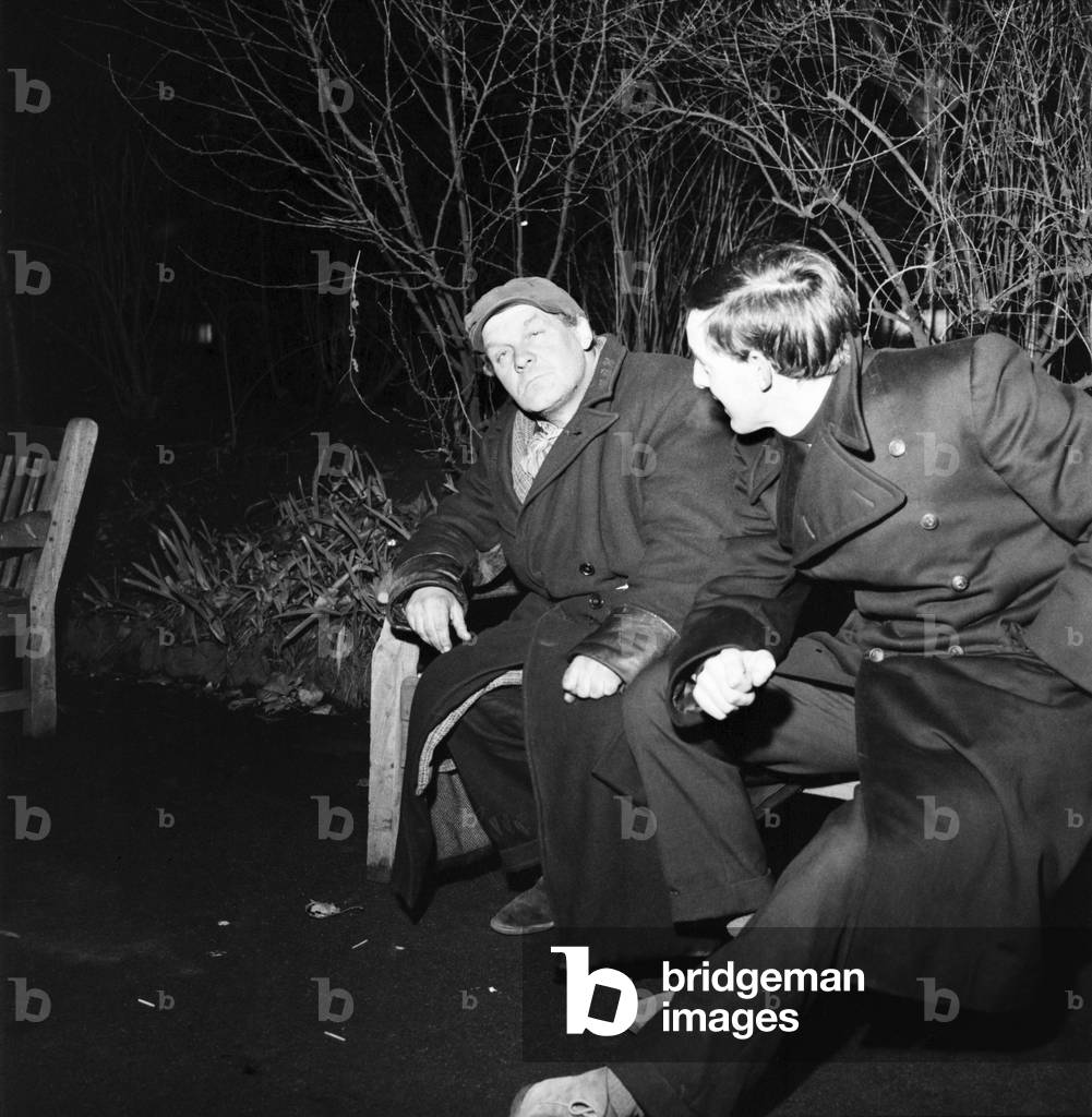 The St. Mungo Community, a voluntary relief organisation among other things, operates a midnight soup run for vagrants, down and outs etc., around London. Helper talking to one of the homeless (wearing cap) after receiving his soup. 
December 1969