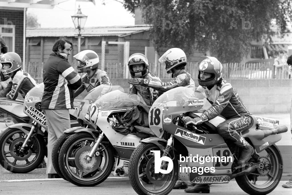 John Player British Grand Prix, Silverstone. Barry Sheene (No. 7) with other 500 cc competitors in assembly area before practice laps, August 1977 (b/w photo)