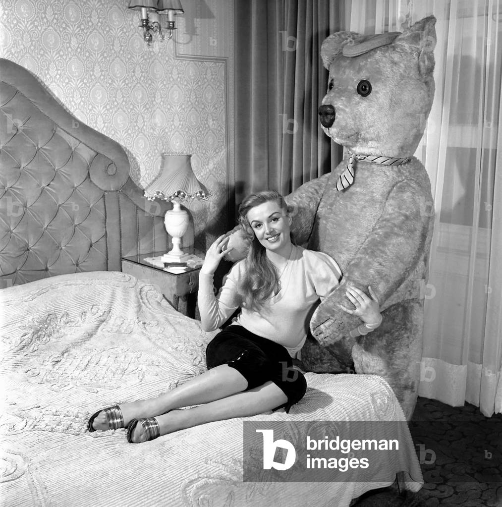 Actress Yana seen here with her pet poodles and a giant teddy bear, March 1959 (b/w photo)
