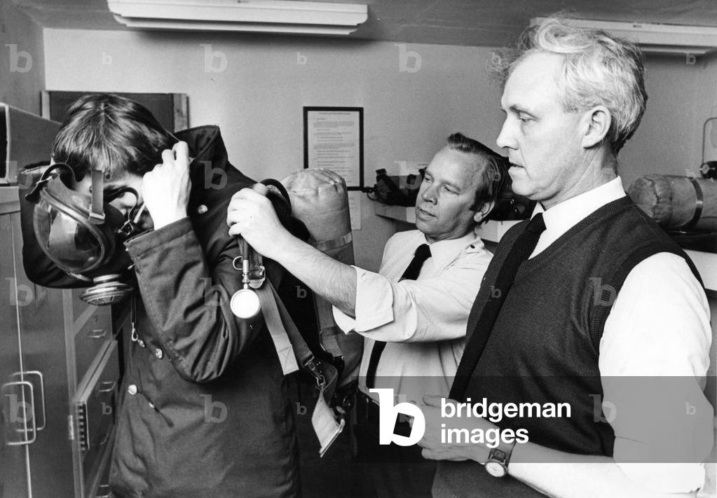 Firefighters Roy Wilson (centre), Harry Phillips handing out advice to Jim Milne about breathing apparatus, 1970