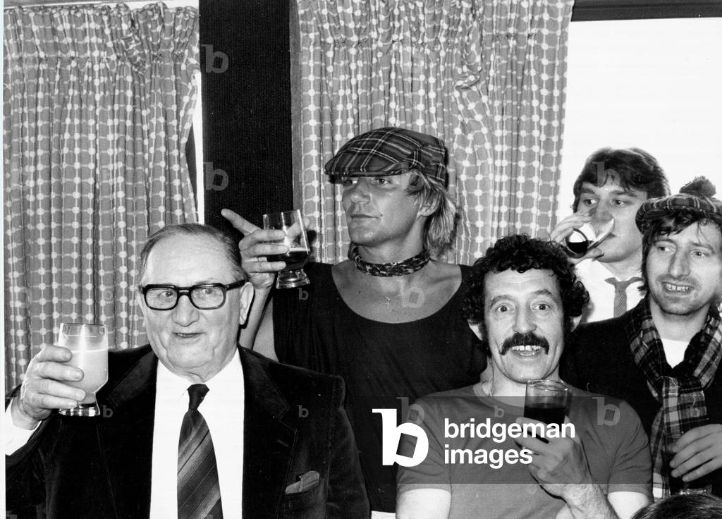 Scotland's Rock superstar Rod Stewart celebrates with a drink after the England v Scotland Home International Championship match, May 1980 (photo)
