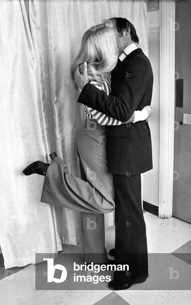 A young couple enjoy a kiss and cuddle