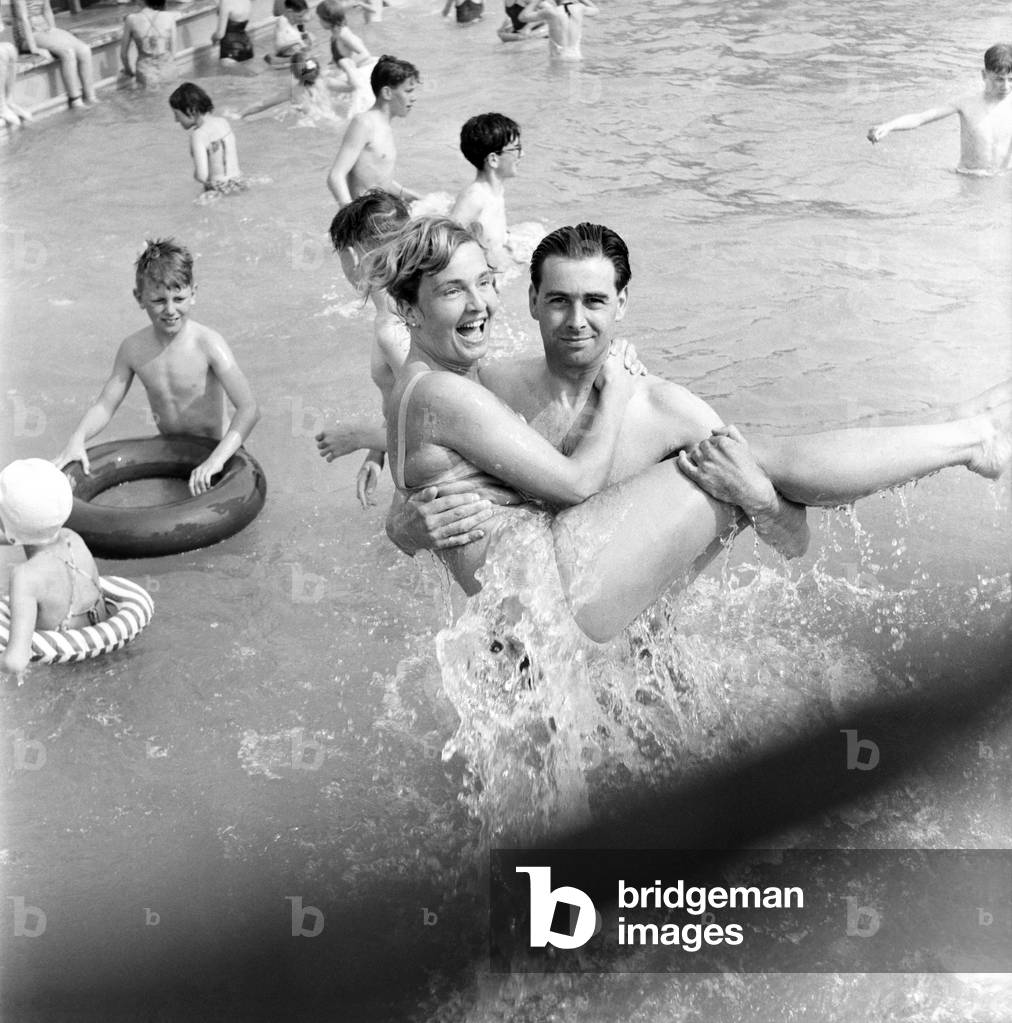 Rhyl bathing pool. Pauline Jones, 23, of Rhyl in the arms of her brother-in-law John Williams of Prestatyn splashing about in the Rhyl bathing pool. June 1960