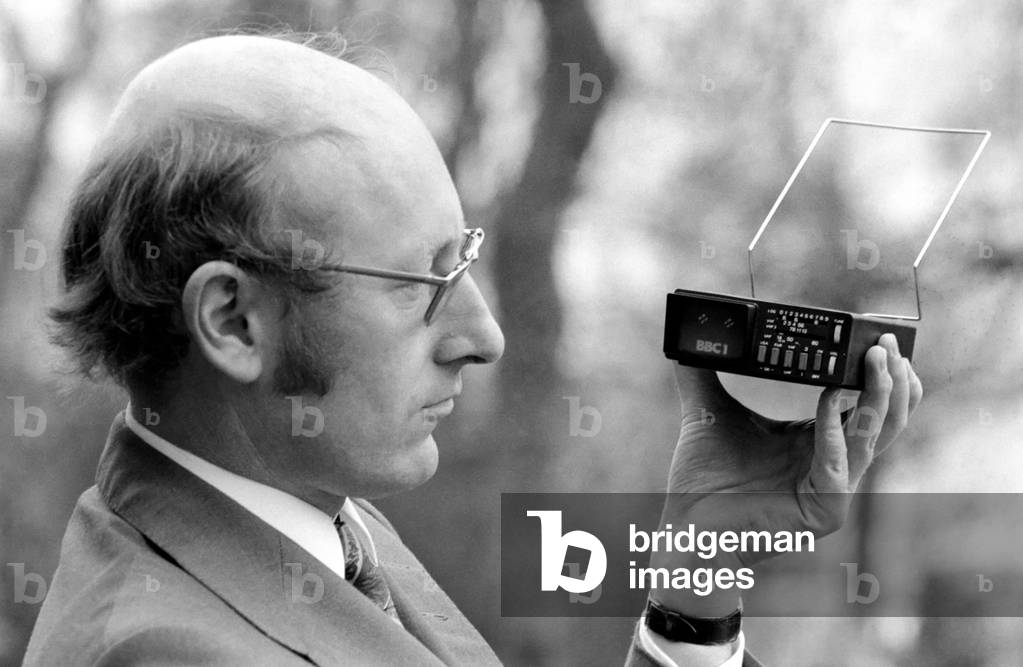 Director of Sinclair Radionics, Mr. Clive Sinclair holding the world's smallest television screen, January 1977 (b/w photo)