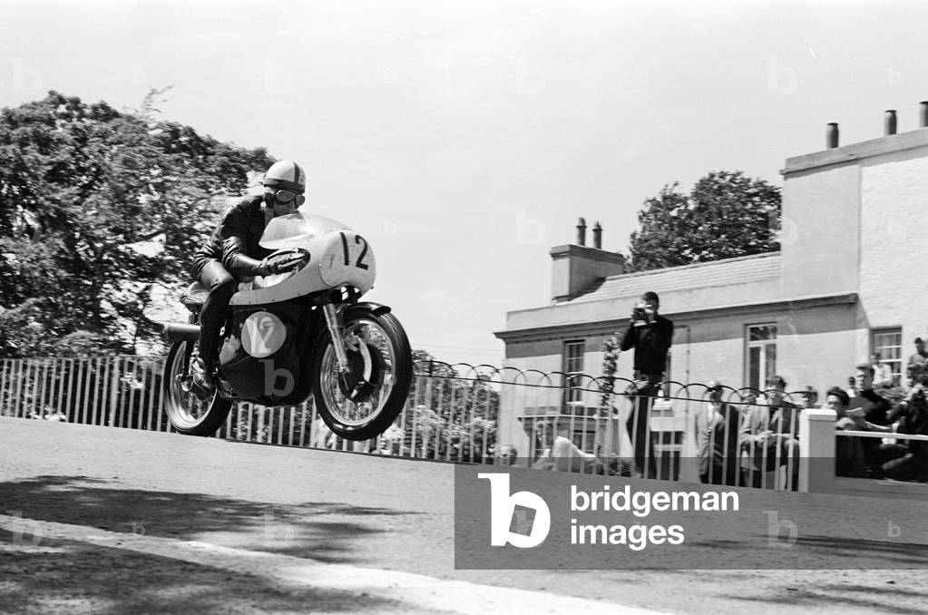Isle of Man TT Races - Junior International. Minter goes over Ballaugh Bridge. 16th June 1965 (b/w photo)