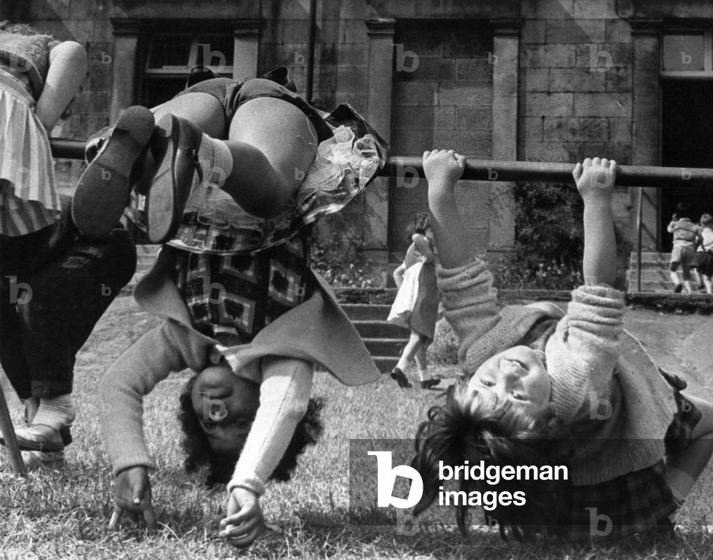 Two young girls showing off their gymnastic skills at Nursery school, 28th May 1964 (b/w photo)