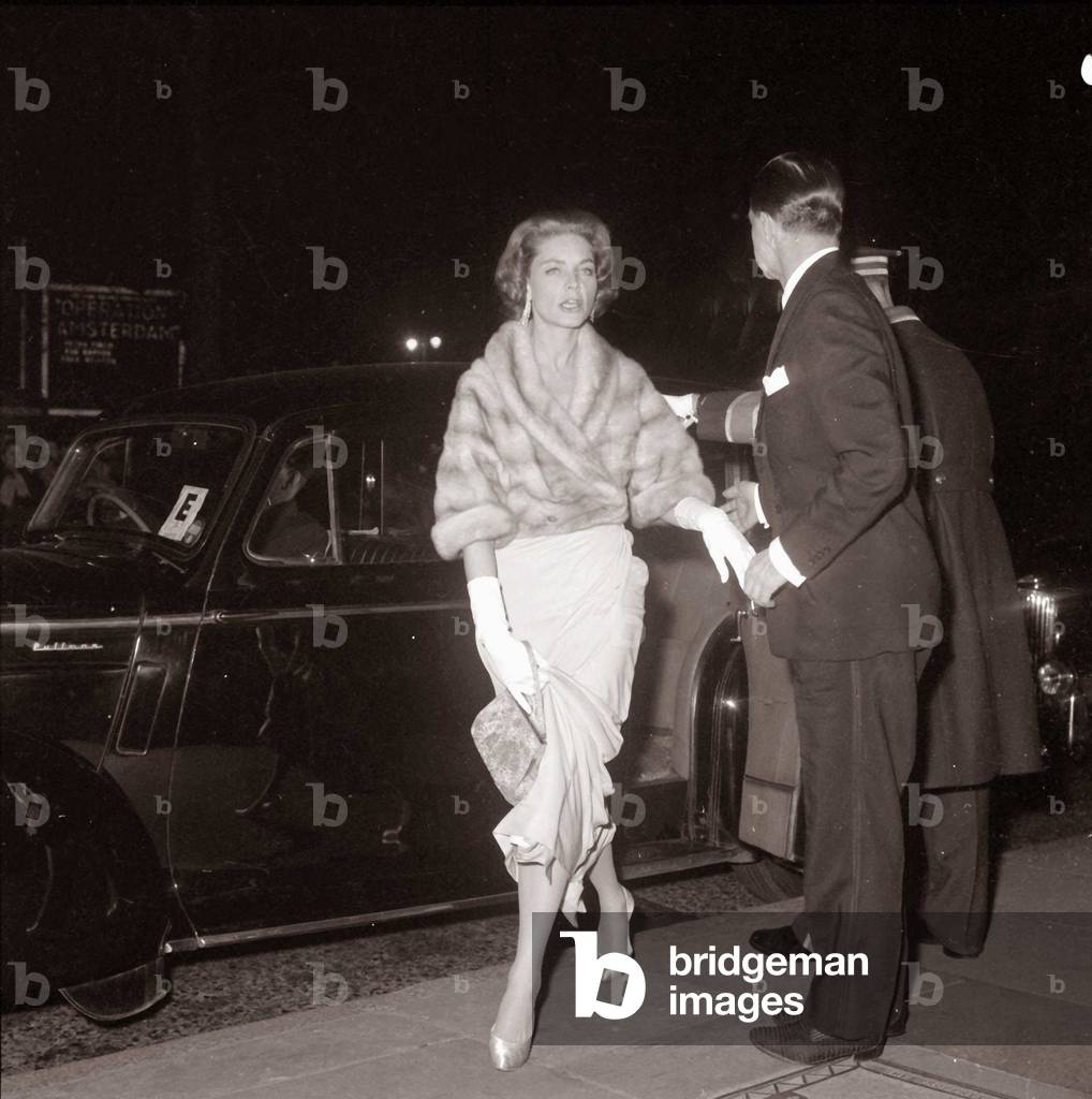 Actress Lauren Bacall is helped out of her car as she arrives at the royal film show The Horses Mouth premiere Film Premiere actress leaving the car fur coat movie star film star chauffeur, February 1959 (b/w photo)