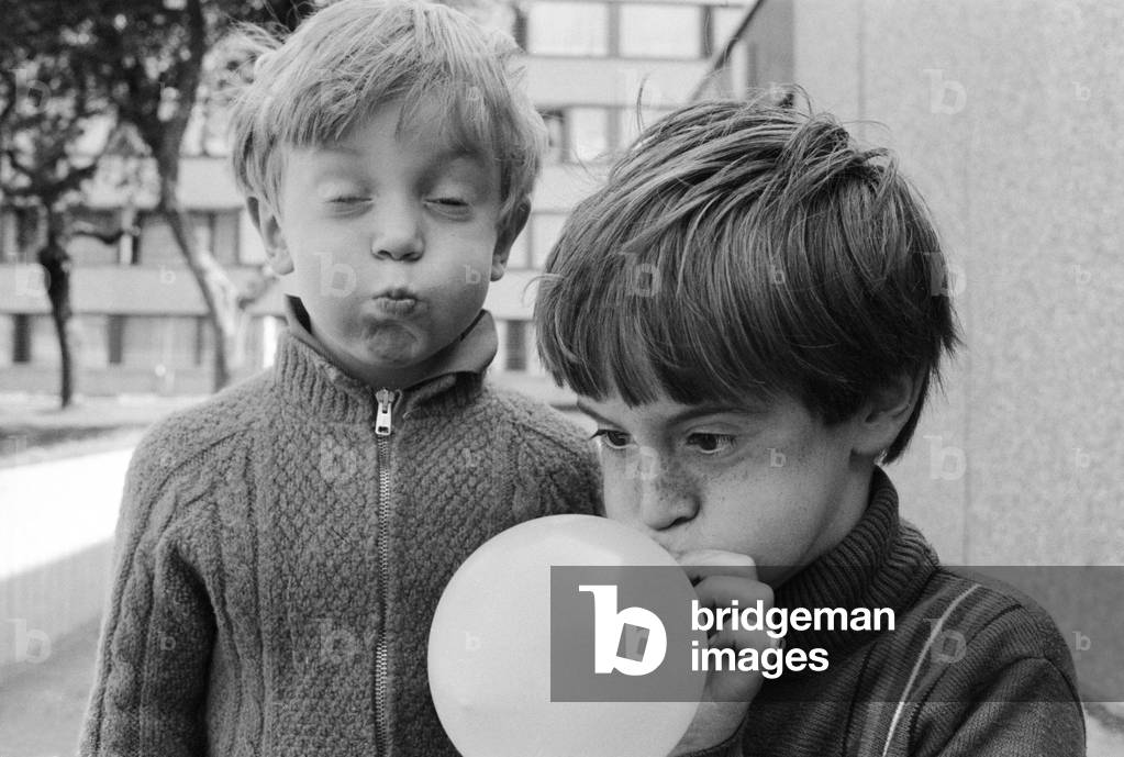 Eight year old Joseph Clifford of Hackney blows up his balloon as his younger brother Paul, aged 5, helps by blowing up an imaginary one, 1st September1970 (b/w photo)