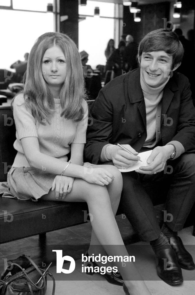 Sport: Football: Liverpool FC left Liverpool Yesterday (Tue) aboard a BEA Comet jet for Portugal. Elaine lnce, 19, of Balewood, Liverpool, sits alongside Peter Wall as he signs his autograph for her. November 1969 (photo)