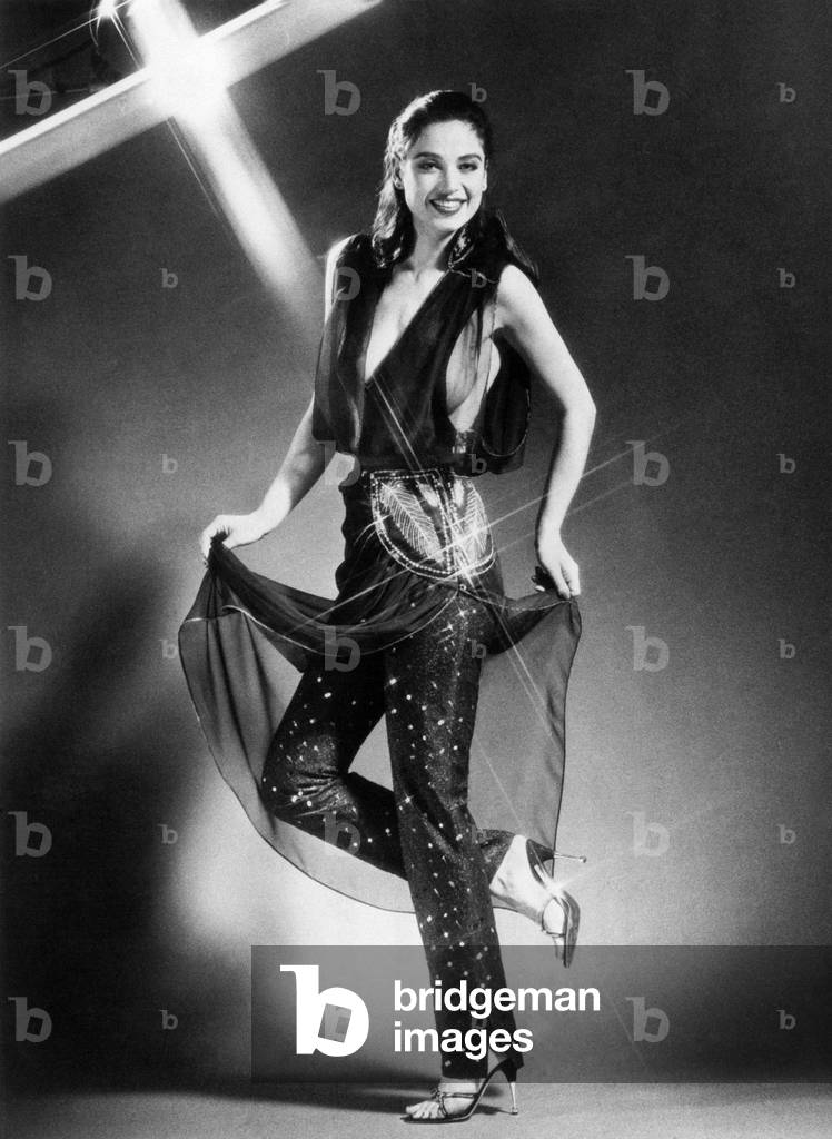 Model wearing a daring chiffon top with narrow trousers. April 1979
